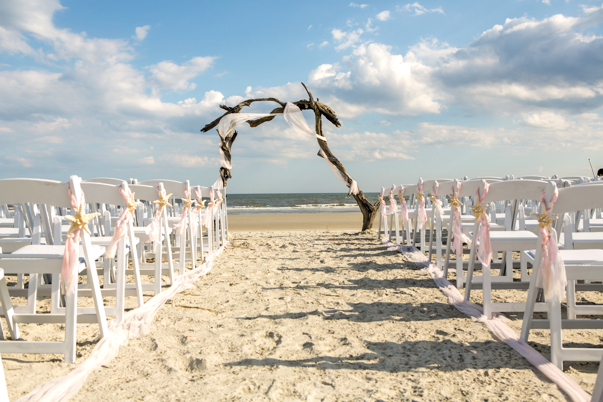 driftwood arch at the end of a wedding aisle setup